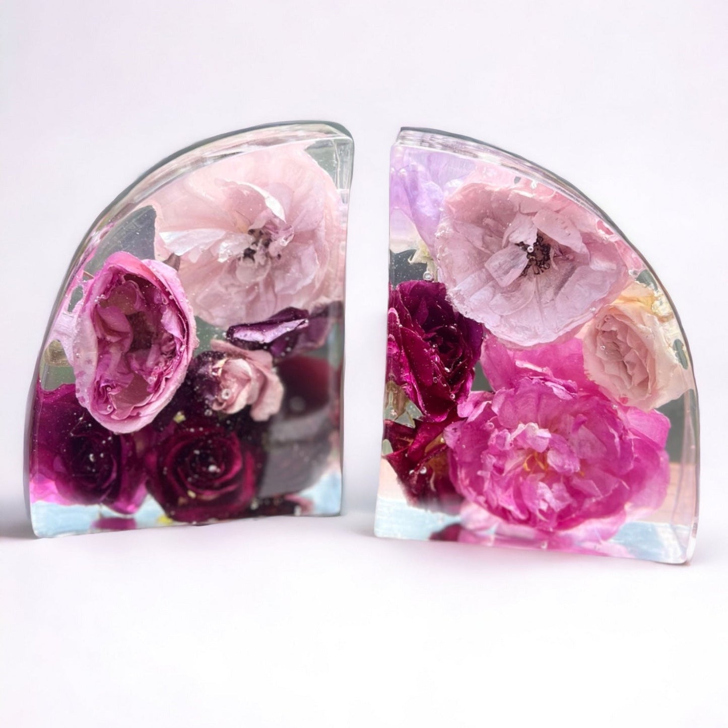 Custom resin bookend set made with pink and burgundy red flowers included a peony , ranunculus , roses , rose , and mini spray roses.  A flower preservation option that is useful home decor forever.