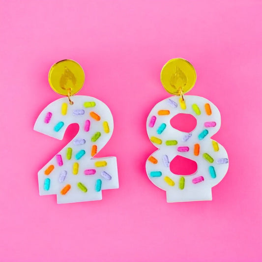 a pair of earrings made of white acrylic shaped like number candles that you put on a birthday cake.  perfect for the birthday girl or woman!