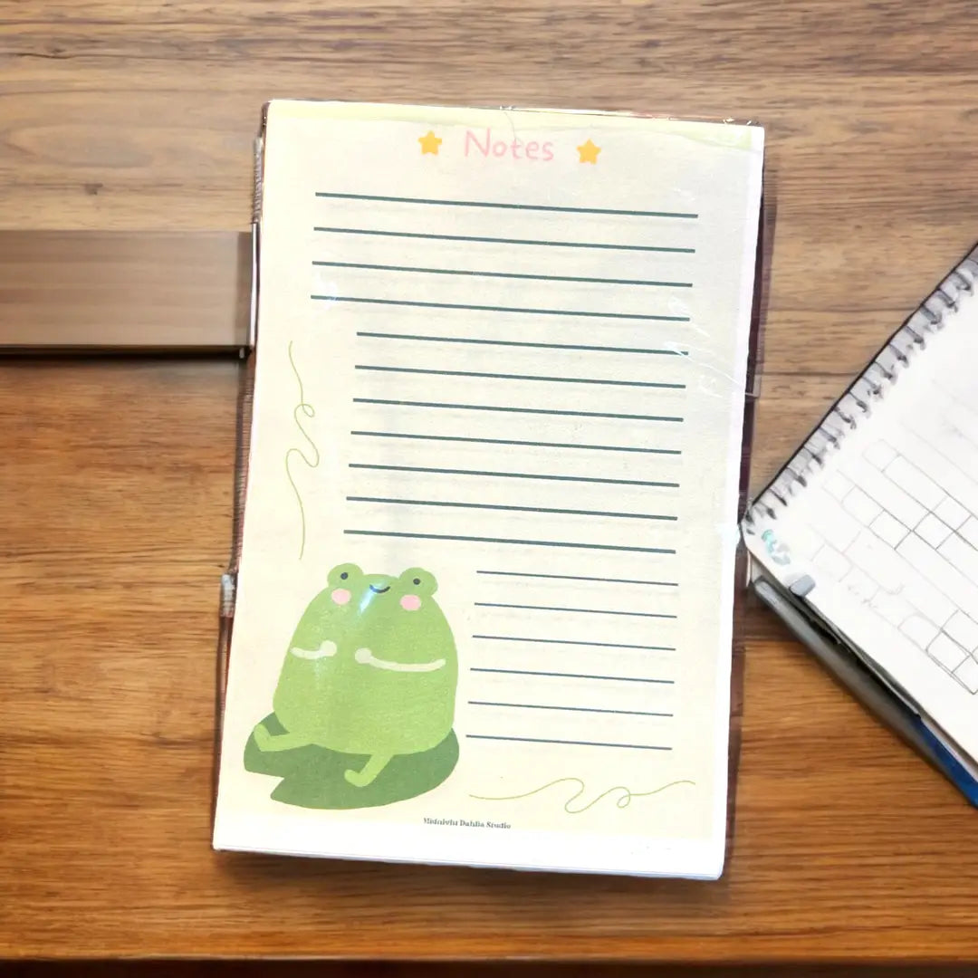 a green lined notepad with a cute chibi frog at the bottom and 'notes' on top in pink