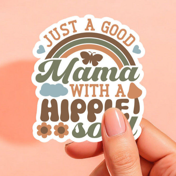 a white background sticker that reads just a good mama with a hippie soul in vintage colors of burnt orange, olive green, and brown, surrounded by a rainbow, butterflies, mushrooms, daisies, and hearts