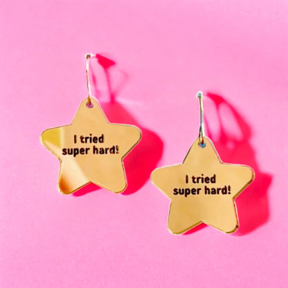 a gold star shaped pair of earrings that read i tried super hard!  a perfect accessory for teachers or any woman women.