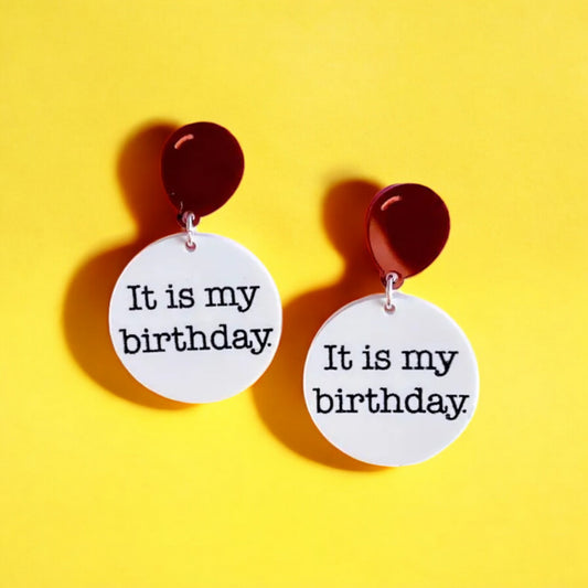 a pair of earrings made of a white acrylic circle with black writing that reads it is my birthday hanging from a red balloon.  perfect jewelry gift for the birthday girl woman.