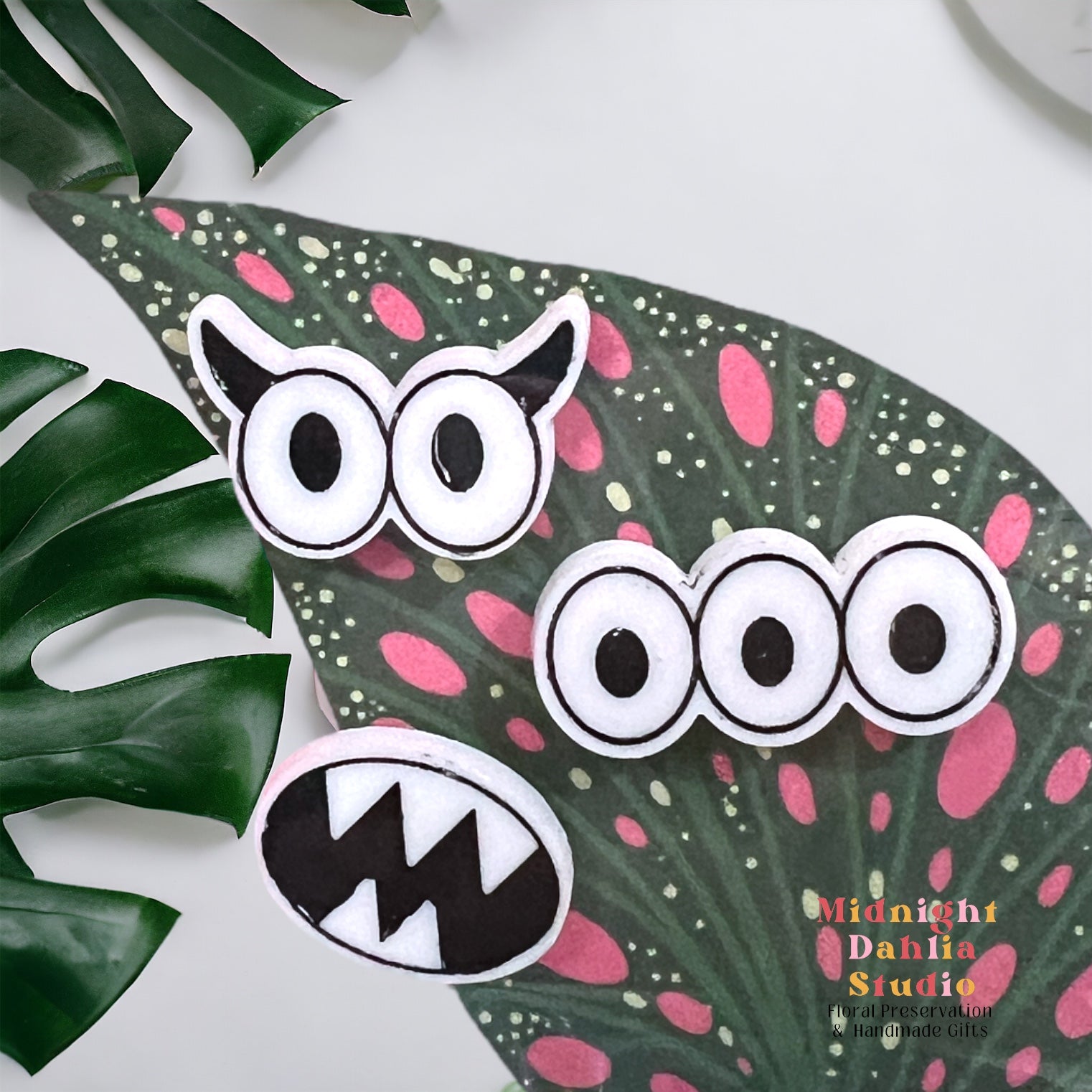 a set of three plant personality magnets with one a pair of googly eyes with horns, a set of three eyes, and a monster mouth with sharp teeth