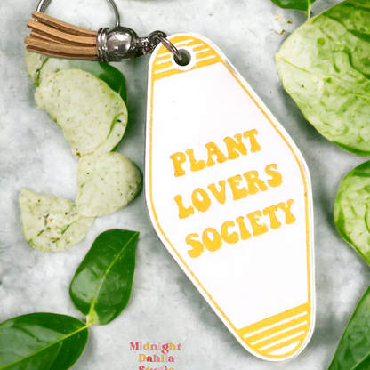 a retro motel keychain made of acrylic that reads plant lovers society