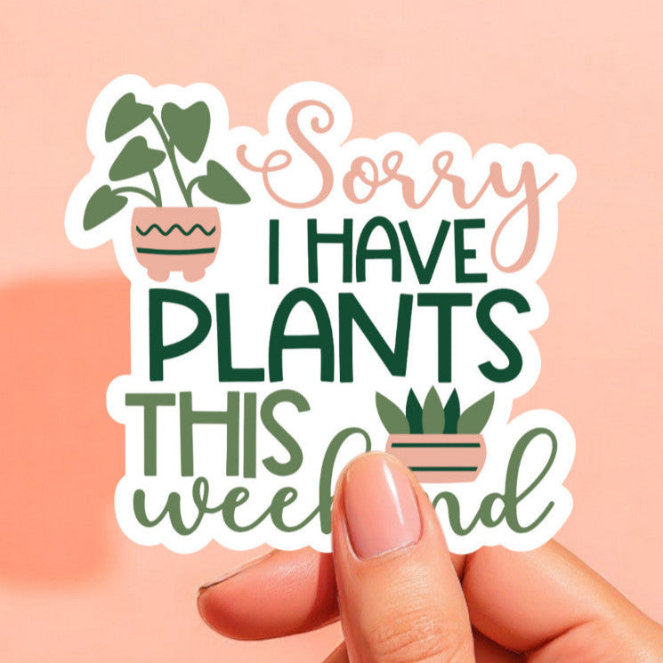 a white sticker that reads sorry i have plants this weekend in peach and green with two potted plants illustrated on the sides