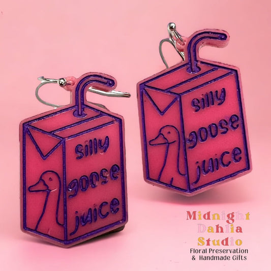 hot pink silly goose juice acrylic earrings in the shape of a juicebox with silly goose juice and the outline of a goose on silver plated hook earring hardware.