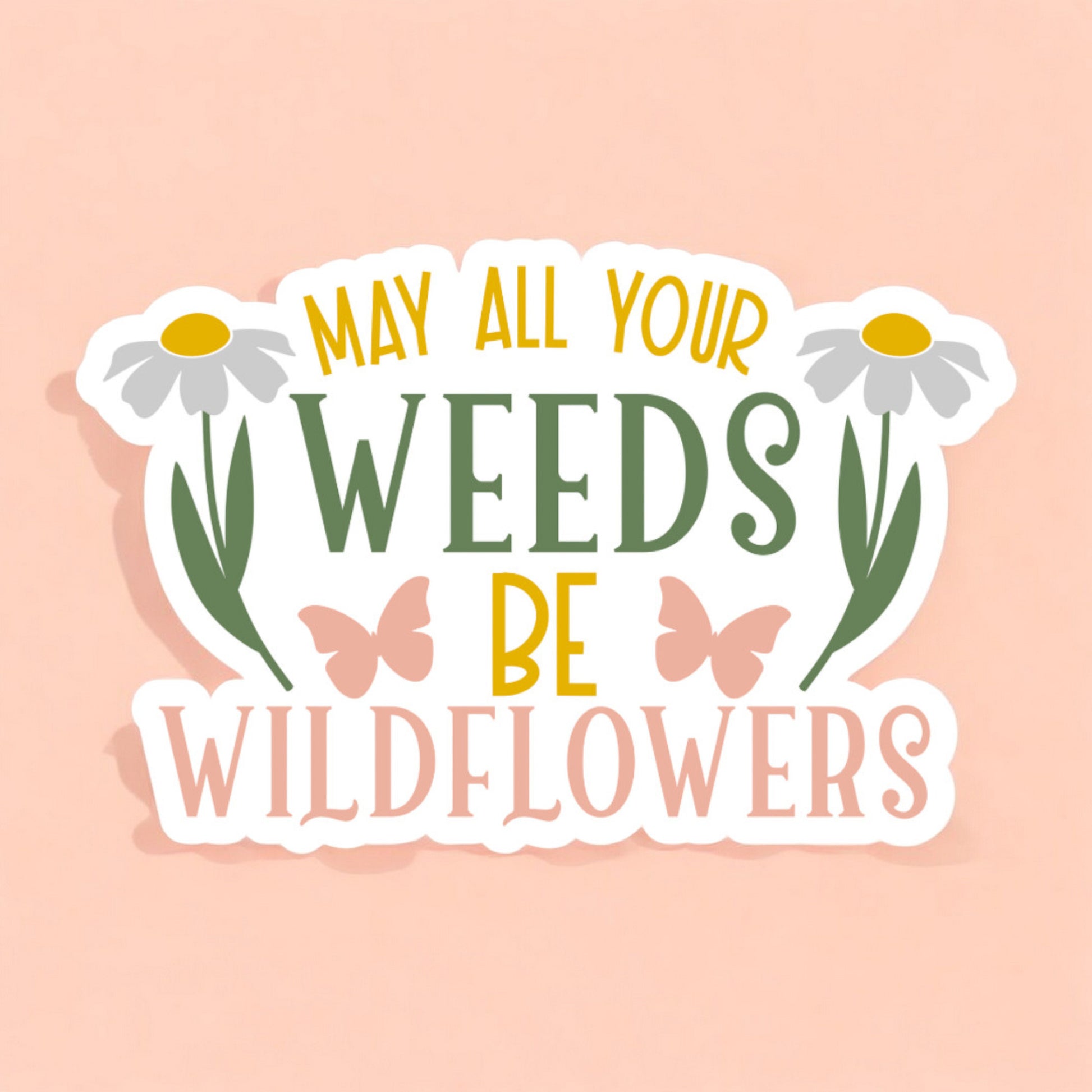 a white sticker that reads may all your weeds be wildflowers in pink green and yellow with a white daisy and pink butterfly on either side