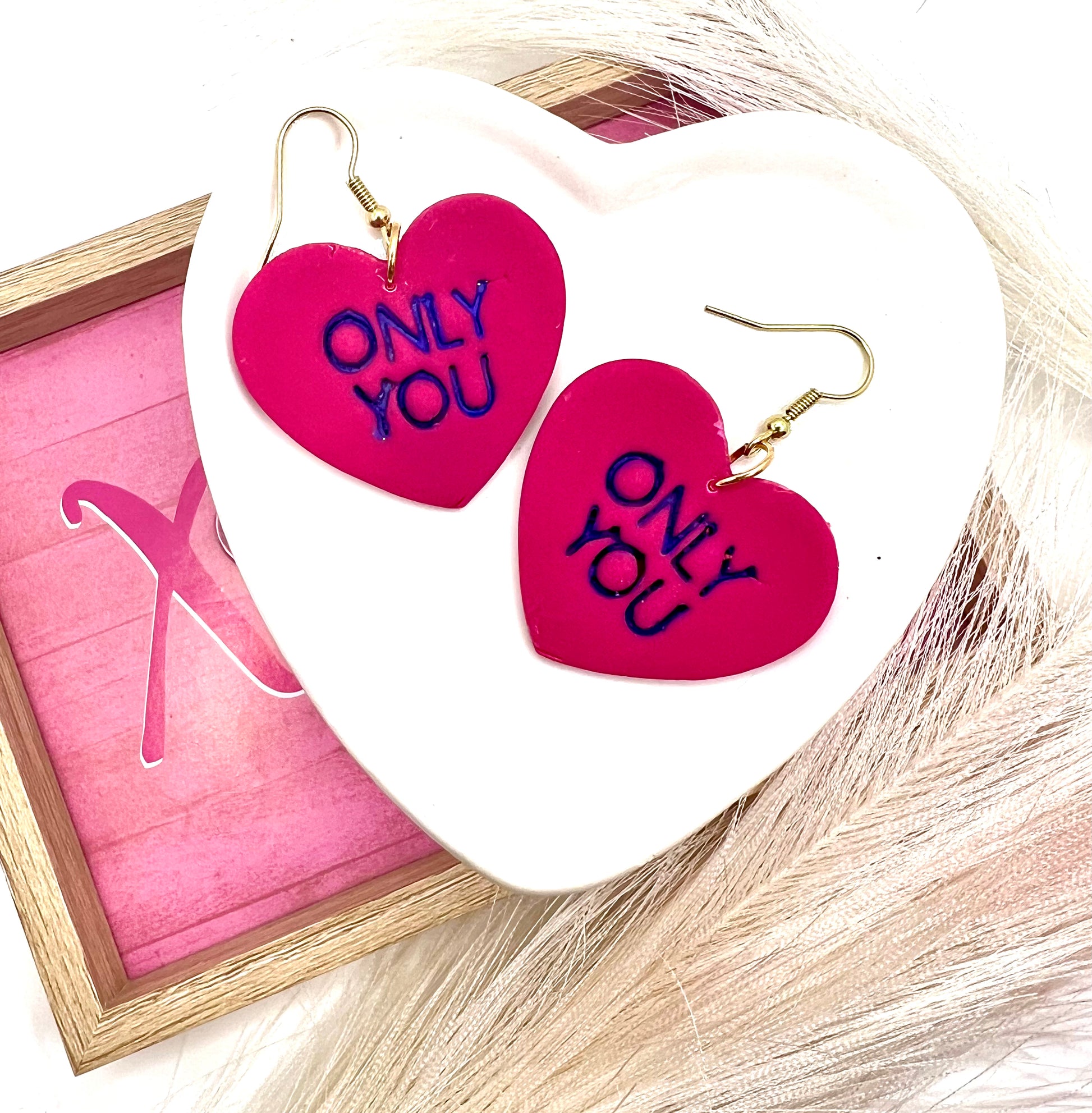 heart shaped earrings with only you stamped in purple.  they are on gold fish hook style earrings.