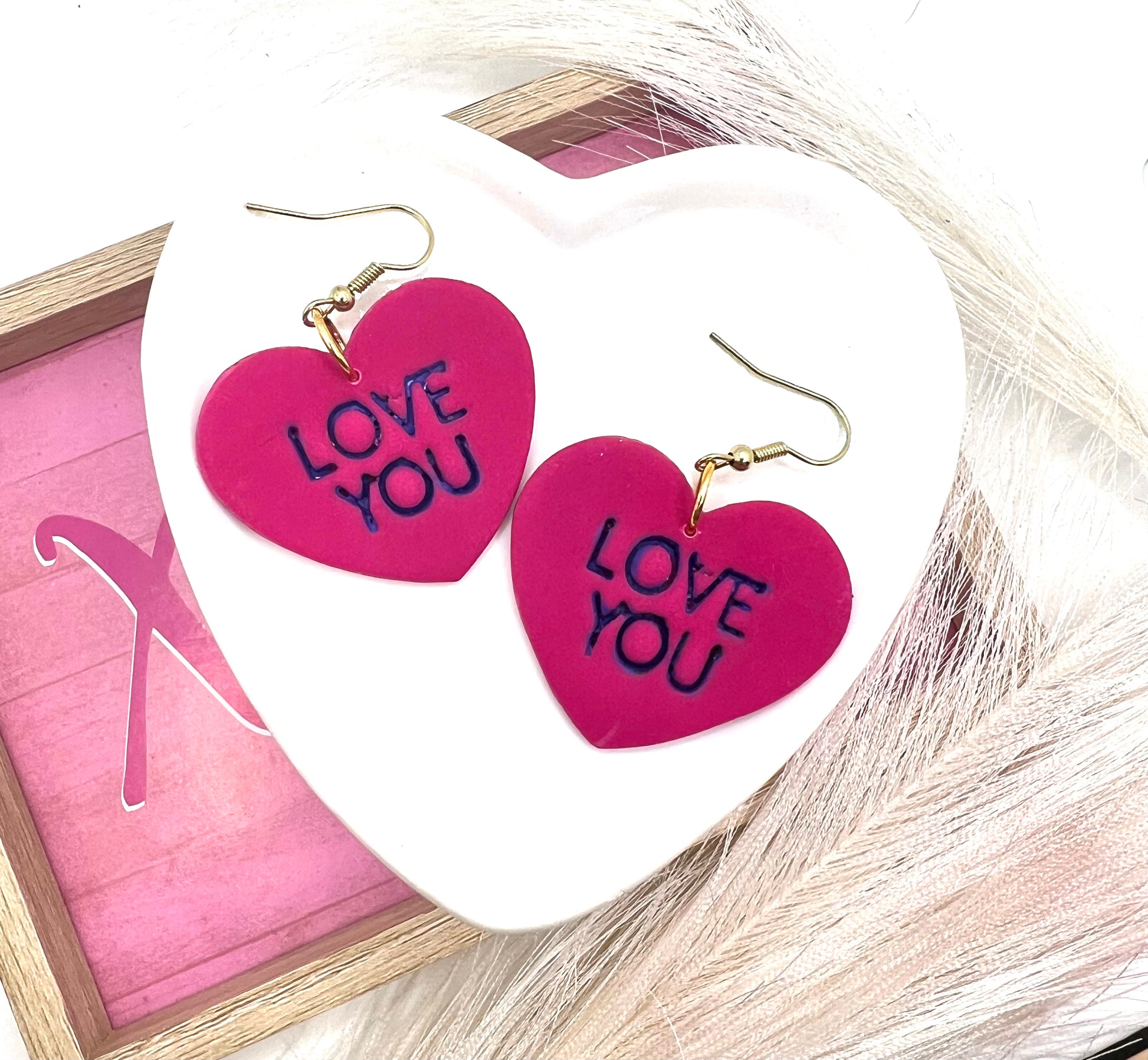 heart shaped earrings with love you stamped in purple.  they are on gold fish hook style earrings.